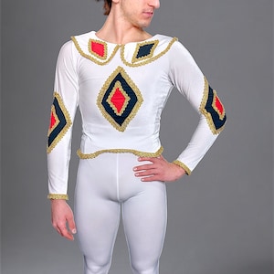 Puede incluir: Un disfraz blanco de manga larga con detalles en forma de diamante en rojo, negro y dorado. El disfraz incluye mallas blancas a juego. El atuendo está adornado con detalles dorados y probablemente sea para una actuación o evento teatral.