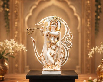 Puede incluir: Una estatua blanca y dorada de la deidad Krishna tocando la flauta, de pie en una pose con las piernas cruzadas. La figura está enmarcada por una gran estructura de halo circular, adornada en oro y blanco, sobre una base negra rectangular.