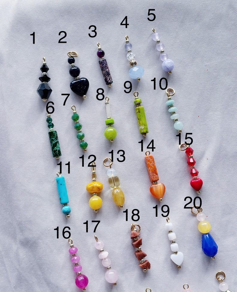 Puede incluir: Veinte cuentas de piedras preciosas surtidas en cadenas doradas, numeradas del 1 al 20. Las cuentas son de varios colores, formas y tama&ntilde;os, incluyendo turquesa, rojo, verde, amarillo, naranja, rosa y azul.