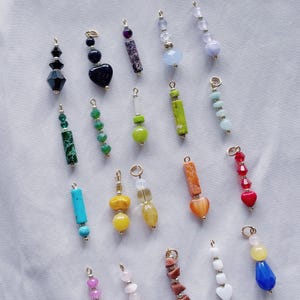 Puede incluir: Surtido de cuentas de piedras preciosas y vidrio de colores enhebradas en cadenas doradas. Las cuentas son de varias formas, incluyendo corazones, cuadrados y rect&aacute;ngulos. Algunas cuentas son facetadas, mientras que otras son lisas.