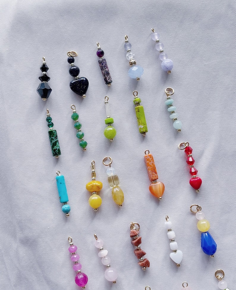 Puede incluir: Surtido de cuentas de piedras preciosas y vidrio de colores enhebradas en cadenas doradas. Las cuentas son de varias formas, incluyendo corazones, cuadrados y rect&aacute;ngulos. Algunas cuentas son facetadas, mientras que otras son lisas.