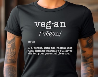 May include: Black t-shirt with white text that reads "veg.an /'vēgən/ noun 1. a person with the radical idea that animals shouldn't suffer or die for your personal pleasure."