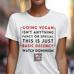 Op de afbeelding: Wit T-shirt met de tekst "Going Vegan Isn't Anything Fancy or Special This is Just Basic Decency Watch Dominion" en een QR-code met een YouTube-logo.