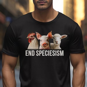 Puede incluir: Camiseta negra con un gráfico blanco de un pollo, un cerdo y un cordero con el texto "END SPECIESISM" debajo.