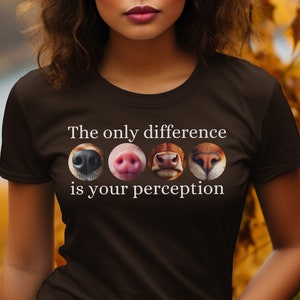 May include: A brown t-shirt with the text "The only difference is your perception" printed in white. Four animal noses are shown in a row above the text: a dog nose, a pig nose, a cow nose, and a cat nose.