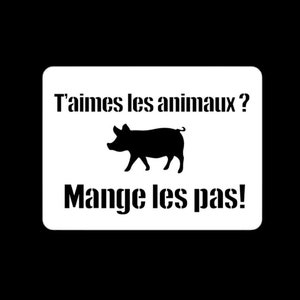 May include: A white sign with black text and a black pig illustration. The sign reads "T'aimes les animaux? Mange les pas!"