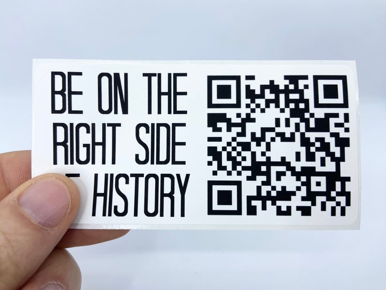 Op de afbeelding: Witte sticker met zwarte tekst die "BE ON THE RIGHT SIDE OF HISTORY" luidt en een zwart-witte QR-code.