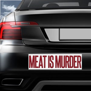 May include: A white bumper sticker with the text "MEAT IS MURDER" in red letters.