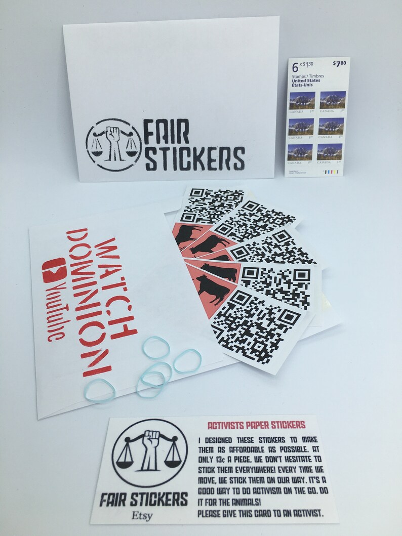 May include: A set of six black and white stickers with a scale and a raised fist. The stickers are designed to be used as activism tools. The text on the card reads "Activists Paper Stickers" and "I designed these stickers to make them as affordable as possible. At only 13&cent; a piece, we don't hesitate to stick them everywhere! Every time we move, we stick them on our way. It's a good way to do activism on the go. Do it for the animals! Please give this card to an activist."