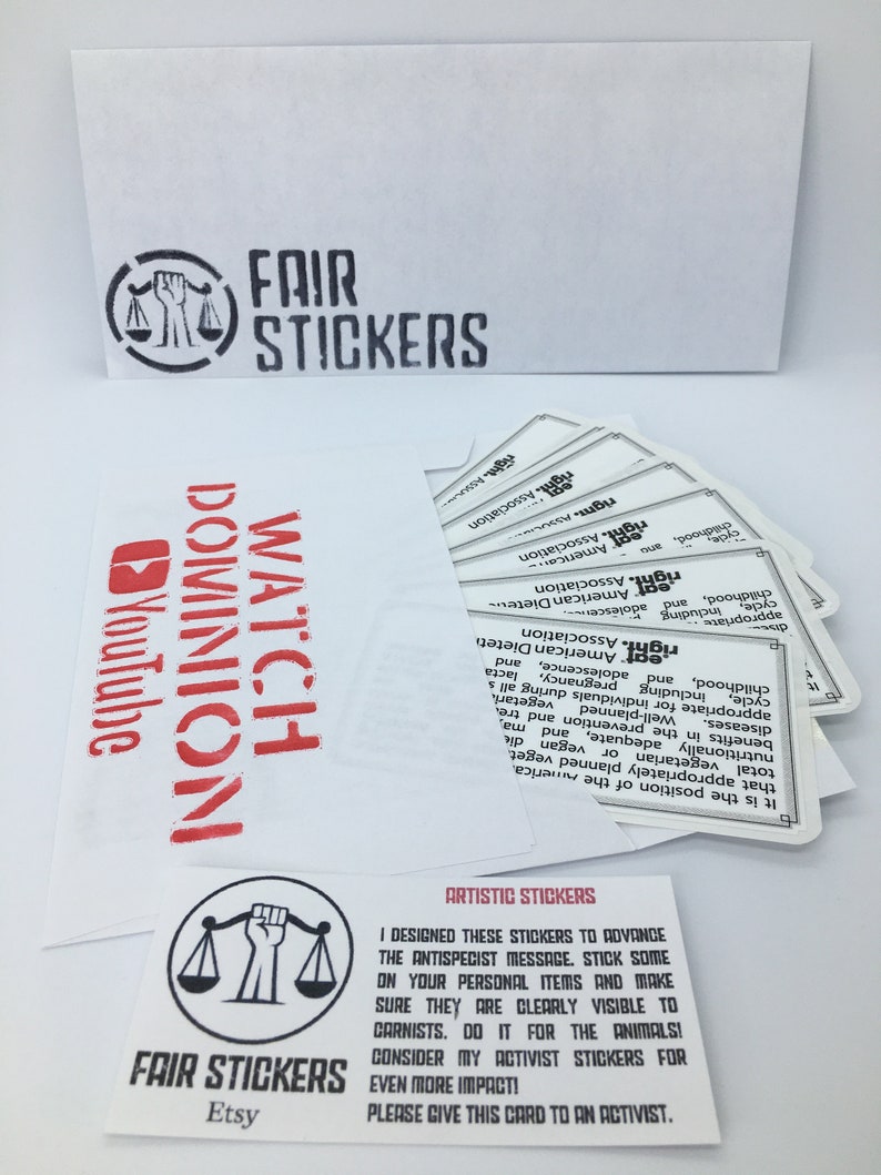 May include: A white card with black text that reads "Artistic Stickers". The card features a black and white illustration of a scale with a raised fist. The text below the illustration reads "Fair Stickers Etsy".