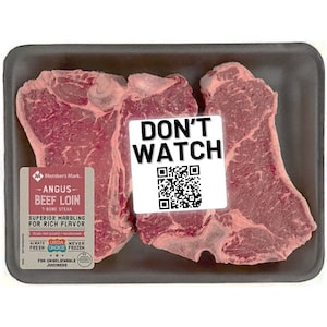 Pode incluir: Dois bifes de T-bone crus em uma bandeja de pl&aacute;stico preto. Os bifes s&atilde;o etiquetados como "Angus Beef Loin" e "Marmoreio superior para um sabor rico". Um adesivo branco com o texto "N&Atilde;O ASSISTIR" e um c&oacute;digo QR est&aacute; nos bifes.