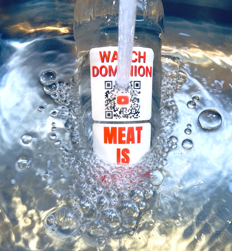 Pode incluir: Uma garrafa de pl&aacute;stico transparente com um r&oacute;tulo branco que diz "Watch Dominion Meat Is" e um c&oacute;digo QR com um bot&atilde;o de reprodu&ccedil;&atilde;o do YouTube vermelho. A garrafa est&aacute; sendo enchida com &aacute;gua e bolhas est&atilde;o se formando.