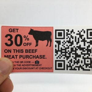 May include: A pink and white sticker with a black silhouette of a cow and the text "GET 30% OFF ON THIS BEEF MEAT PURCHASE." A QR code is on the right side of the sticker.