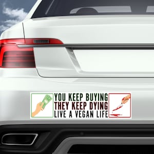 May include: A white car with a bumper sticker that reads "You keep buying they keep dying live a vegan life". The sticker has two images, one of a hand holding money and the other of a bloody knife.