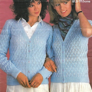 May include: Two women wearing light blue knitted cardigans with a lace pattern. The cardigans have a V-neck and button closure. The cardigans are sized for 32-44 inches or 81.5-111.5 centimeters.