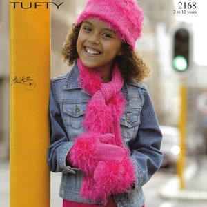 May include: A young girl wearing a pink knitted hat, scarf, and mittens. She is also wearing a denim jacket and a pink skirt with a heart design. The image includes the text "TUFTY" and "2168 2 to 12 years".