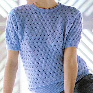 May include: A light blue knitted sweater with a delicate openwork pattern and short sleeves.
