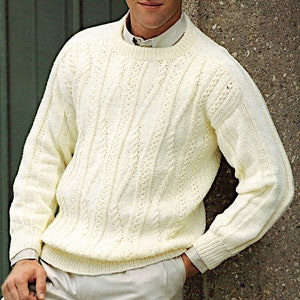 以下が含まれることがあります： ケーブル編みのパターンが入った白いニットセーター