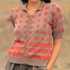 May include: A short-sleeved knitted cardigan with a checkered pattern in shades of brown and orange. The cardigan has a button-up front and a collared neckline.