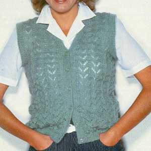 May include: A green knitted waistcoat with a button-up front and a lacy pattern. The waistcoat is sleeveless and has a V-neck.
