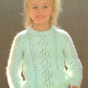 May include: A light green knitted jumper with a delicate lace pattern. The jumper has a round neckline and long sleeves.