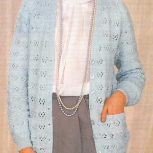 May include: A light blue knitted cardigan with a delicate openwork pattern. The cardigan has a V-neck, long sleeves, and a button closure. It features two pockets on the front.