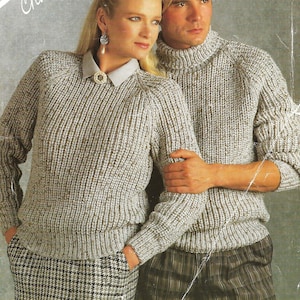 Könnte beinhalten: Zwei Strickpullover in beige und weiß mit einer grobmaschigen Strickstruktur. Die Pullover haben einen runden Halsausschnitt und lange Ärmel. Die Pullover sind für einen Brustumfang von 32 bis 46 Zoll oder 81 bis 117 Zentimeter geeignet.