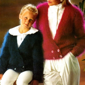 Può includere: Due persone indossano cardigan pelosi. La persona a sinistra indossa un cardigan blu scuro e la persona a destra indossa un cardigan rosa.