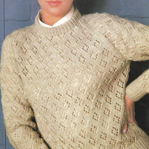 Könnte beinhalten: Ein beiger Strickpullover mit einem zarten Lochmuster. Der Pullover hat einen runden Ausschnitt und lange Ärmel. Preiscode B 8098, CAN $1.00, 81-107 cm, 32-42 in.