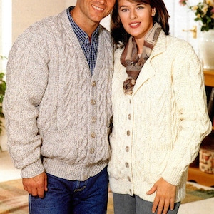 May include: A couple wearing matching cable knit cardigans. The man's cardigan is gray and the woman's cardigan is white.