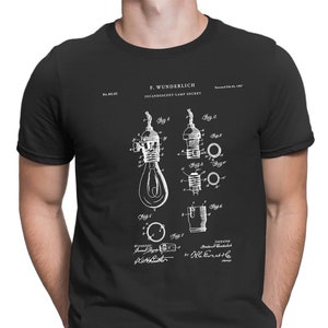 Könnte beinhalten: Ein schwarzes T-Shirt mit einem weißen Druck einer Patentzeichnung für eine Glühlampenfassung. Die Patentzeichnung zeigt eine detaillierte Illustration der Fassung und ihrer Komponenten. Der Text auf der Zeichnung lautet "F. Wunderlich Incandescent Lamp Socket" und enthält die Patentnummer und das Datum.