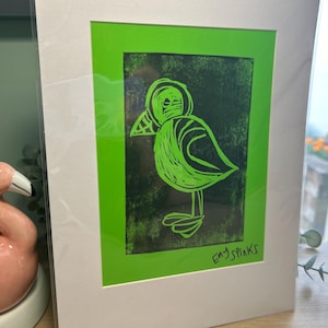 Percy Puffin in black ink original lino cut print on Green A4 mounted by Emy Spinks