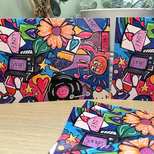 May include: Vibrant art prints in a pop art style. The designs incorporate flowers, hearts, a vintage camera with the word "SNAP!", and a soda bottle. The word "LOVE" is also visible in the design.
