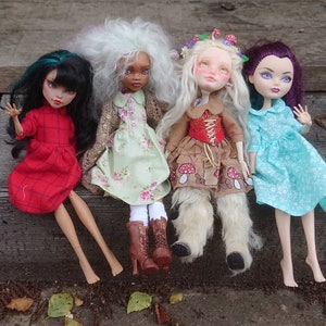 May include: Four dolls sitting on wooden steps. The dolls are wearing different dresses and have different hair colors and styles. The doll on the left is wearing a red dress with a plaid pattern. The doll in the middle is wearing a green dress with a floral pattern. The doll on the right is wearing a blue dress with a floral pattern. The doll in the back is wearing a white dress with a floral pattern.