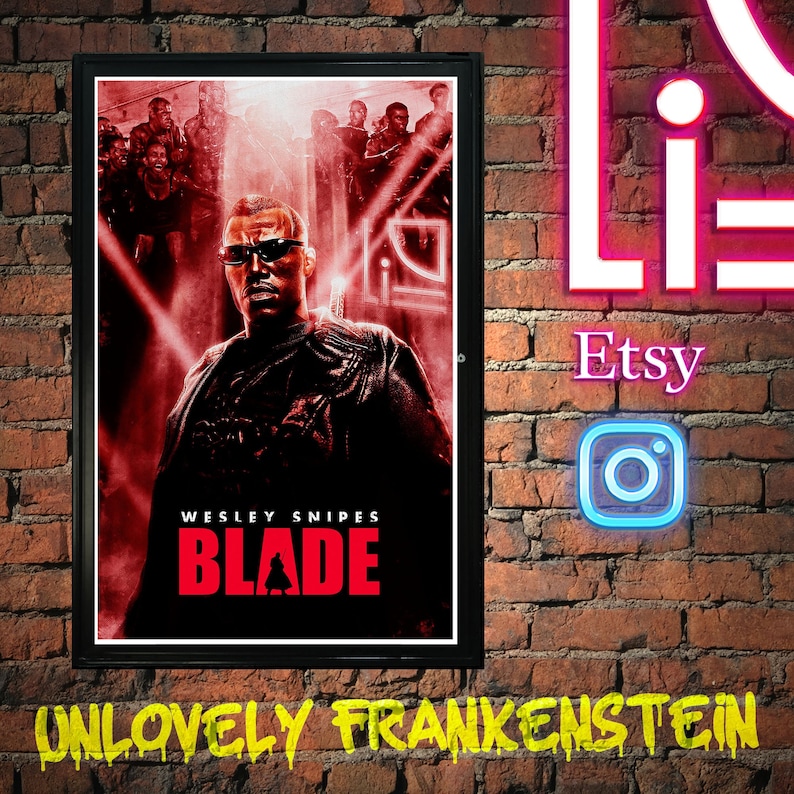 May include: A red and black movie poster featuring Wesley Snipes as Blade, a vampire hunter. The poster has the title "Blade" in large red letters and the text "Wesley Snipes" in smaller white letters.