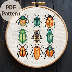 May include: A cross-stitch pattern featuring nine colorful beetle designs in a circular embroidery hoop. The beetles are in shades of green, orange, and blue, with black details. The text "PDF Pattern" is in the upper left corner.