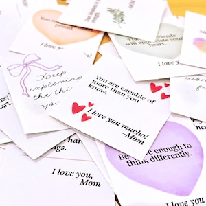 May include: A collection of white cards with various handwritten messages and illustrations. Some cards feature heart shapes, bows, and watercolor designs. Text includes phrases like "I love you," and "Stay colorful."