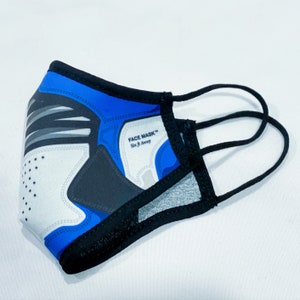 May include: Blue, black, and white face mask with a graphic print of a sneaker. The mask has elastic ear loops and the text "FACE MASK&trade; Six ft. Away" printed on the side.