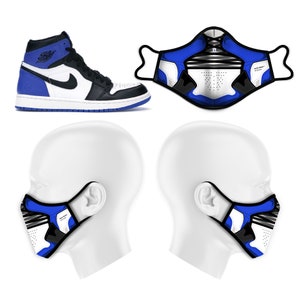 May include: A pair of white and blue face masks with a black and white graphic design inspired by a basketball shoe. The masks are shown on two white mannequins' heads.
