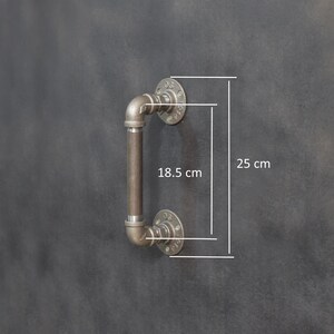 May include: A black metal industrial style door handle with a 18.5 inch long handle and 10 inch tall flanges.