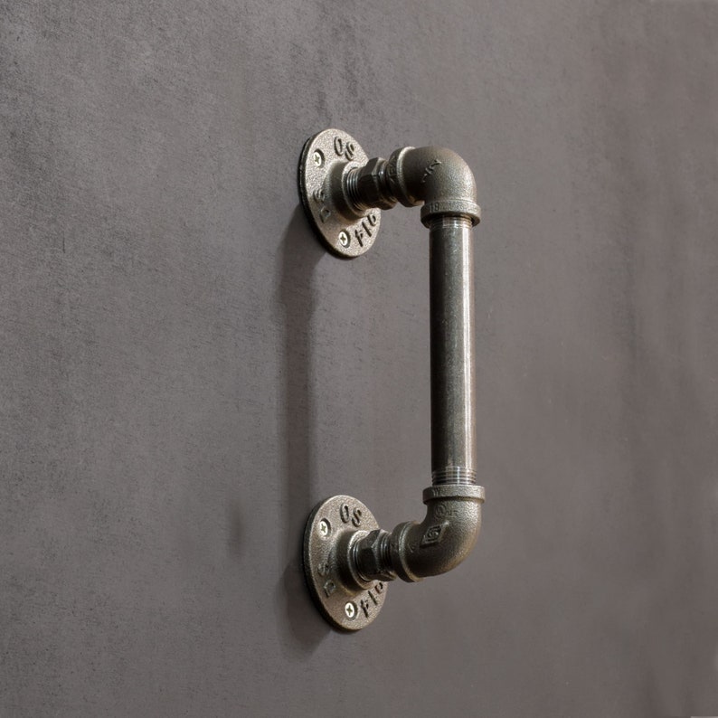 May include: A black metal industrial style door handle with a pipe design. The handle has two round flanges with the text "08" and "01" on them.