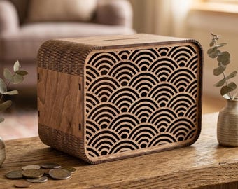 May include: A rectangular wooden money box featuring a laser-cut front panel with a repeating black and brown arched wave pattern. The box has rounded corners, a coin slot on the top surface, and visible wood grain texture on the side panels.