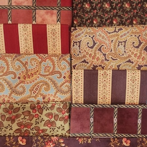 May include: A collection of fabric swatches in various patterns and colors. Designs include floral, paisley, and striped patterns in shades of red, brown, gold, and blue. The fabrics appear to be cotton or a similar material.