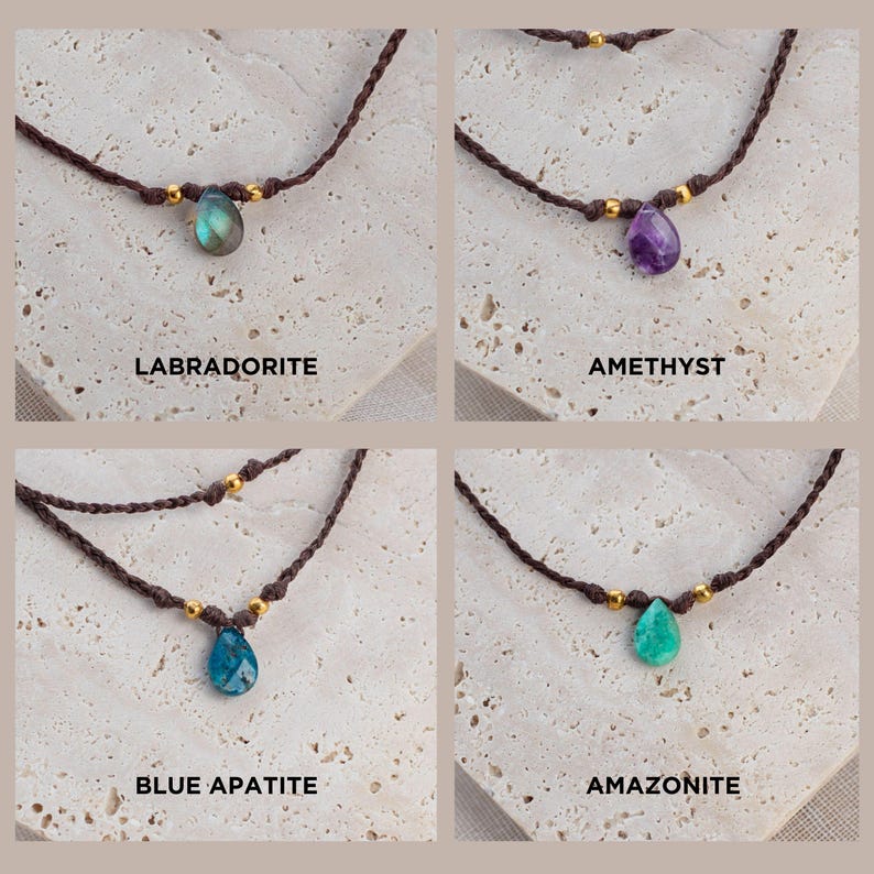 May include: Four necklaces with different gemstone pendants. The necklaces are made of brown cord and have gold beads. The gemstones are labradorite, amethyst, blue apatite, and amazonite.