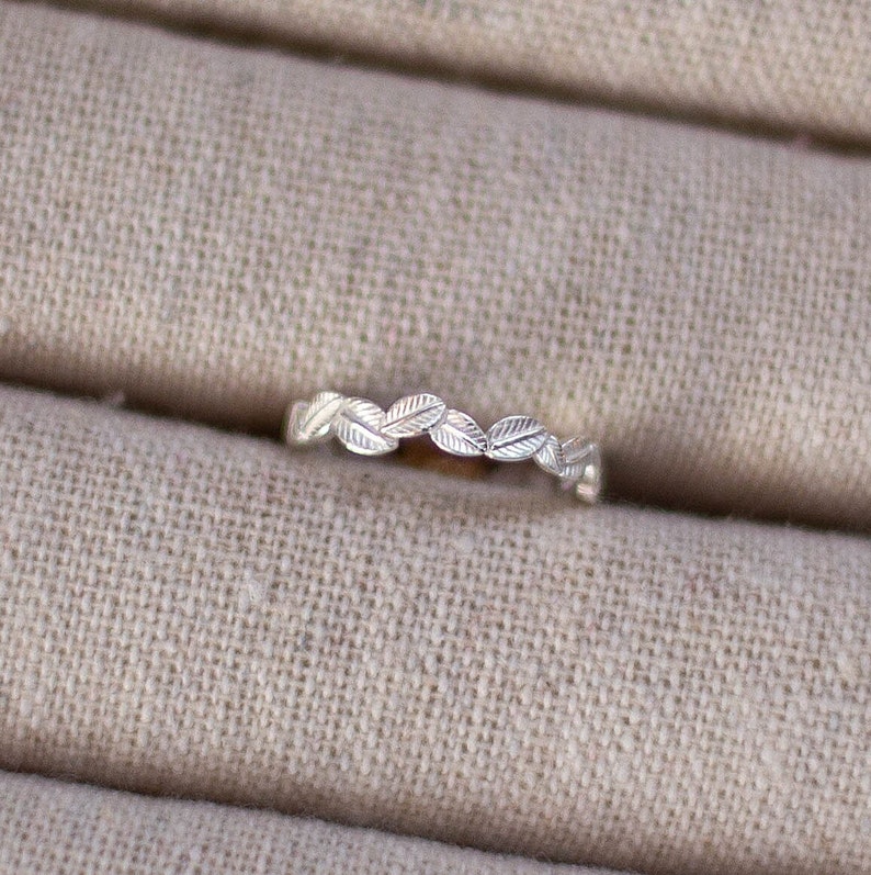 May include: A silver ring with a delicate leaf design. The ring is simple and elegant, perfect for everyday wear.