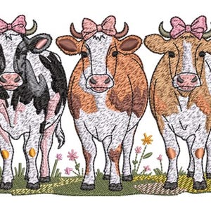 Peut inclure: Broderie représentant trois vaches, chacune ornée d'un nœud rose. Les vaches ont des motifs de robe distincts : noir et blanc, marron et blanc, et beige et blanc. Elles se tiennent dans un champ herbeux avec des fleurs.