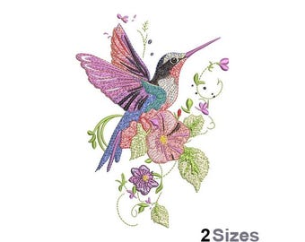 Pode incluir: Design bordado de um beija-flor com asas abertas, em tons de rosa, roxo, azul e verde. A ave está rodeada por flores e folhagens delicadas, com o texto "2 Sizes" na parte inferior. Fundo branco.