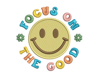 Può includere: Un viso sorridente giallo con un contorno marrone è circondato dalle parole "Focus on the good" in un arcobaleno di colori. Le parole sono disposte in cerchio attorno al viso sorridente.