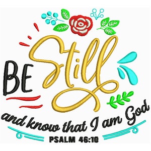 May include: A white background with a gold, black, and red embroidered design. The design features a floral wreath with a red rose and green leaves. The text "BE STILL and know that I am God" is written in black and gold. The text "PSALM 46:10" is written in black below the design.