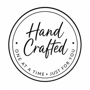 A black and white circular logo with the script text Hand Crafted in the center and the words ONE AT A TIME JUST FOR YOU along the bottom curve.